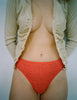 front shot lifestyle image of woman wearing beige cardigan and red lace panty