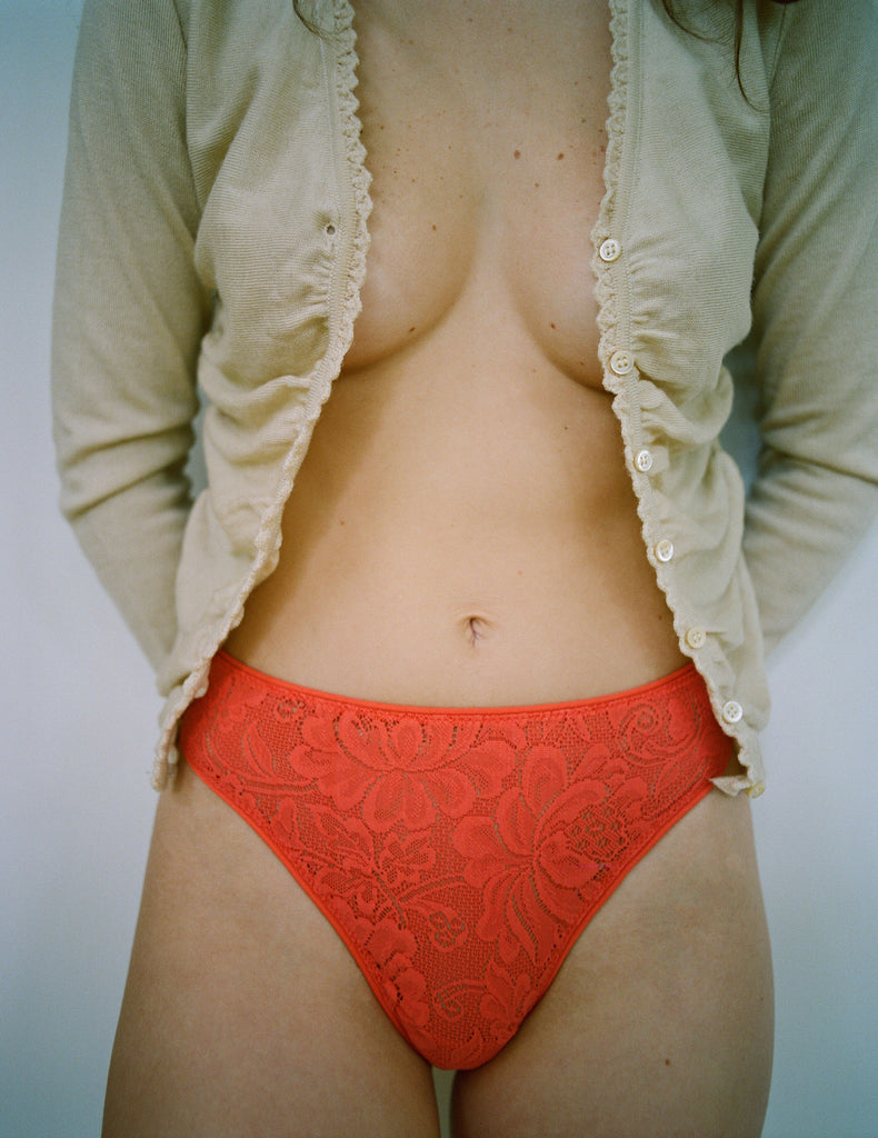 front shot lifestyle image of woman wearing beige cardigan and red lace panty