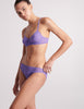 three quarter view on model of purple lace bra and panty